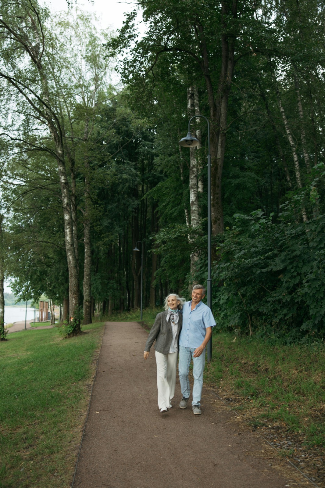 Couple de seniors marchant tranquillement sur un chemin arboré